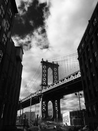 Low angle view of manhattan bridge against cloudy sky