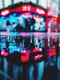 Close-up of illuminated reflection in city at night