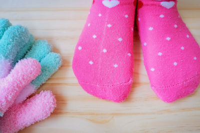 Low section of woman wearing pink socks on hardwood floor