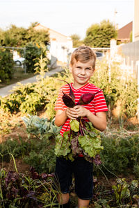 Happy boy holding plant