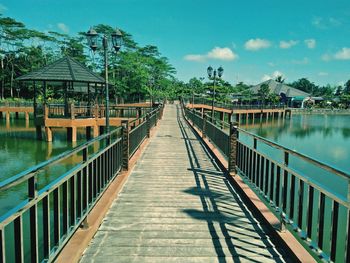 Footbridge over river against sky