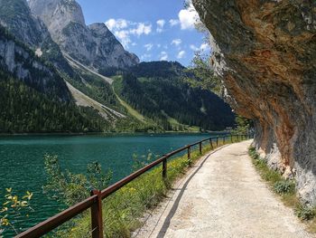 Scenic view of road by mountains against sky