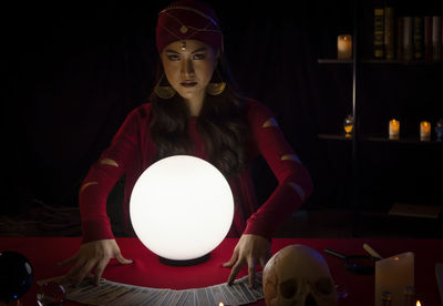 Portrait of female fortune teller with sphere at home