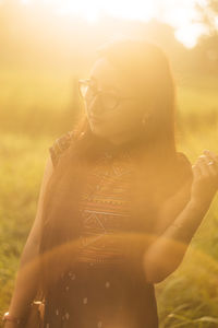 Close-up of young woman standing against sky