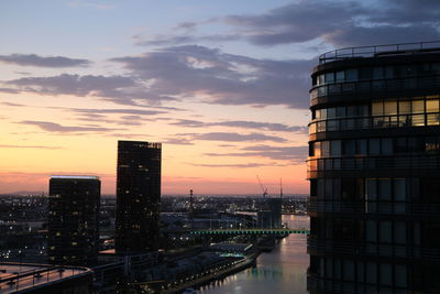 Illuminated buildings against sky during sunset