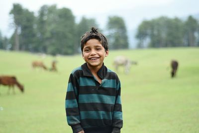 Portrait of smiling boy standing on field