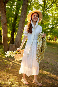 Portrait of woman standing against trees