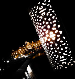 Low angle view of illuminated lights against sky at night