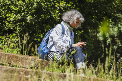 Side view of woman sitting on field