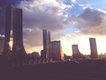 Skyscrapers against cloudy sky