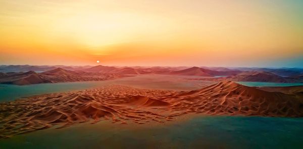 Scenic view of desert against sky during sunset