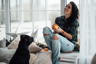 Woman with dog sitting at home