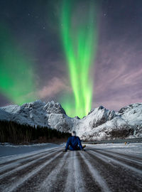 Car on road against snowcapped mountain at night