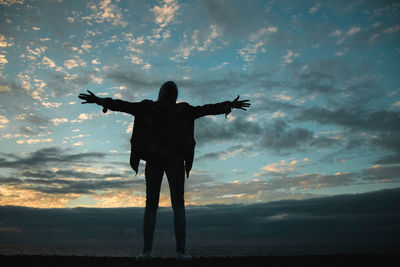 Full length rear view of silhouette man standing against sky