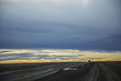 Empty road against sky during sunset