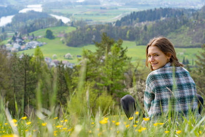 Portrait of young woman standing on field