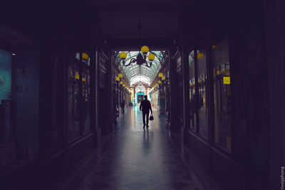 Man and woman in illuminated corridor