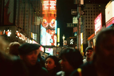 People walking on city street at night