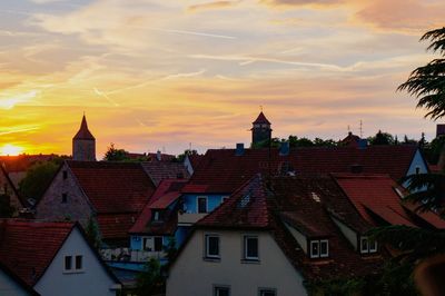 Houses in town against sky during sunset