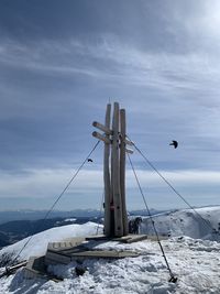 Windmills by sea against sky during winter