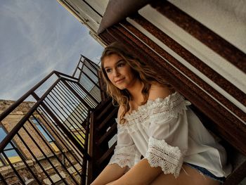 Portrait of smiling woman on staircase