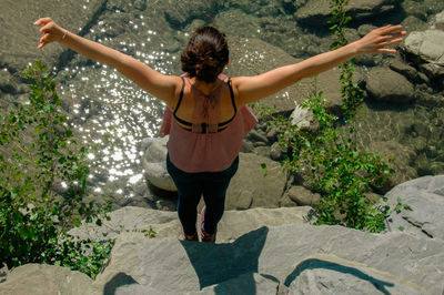 Rear view of woman standing on rock