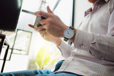 Midsection of woman working with mobile phone