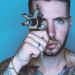 Close-up portrait of young man holding machinery