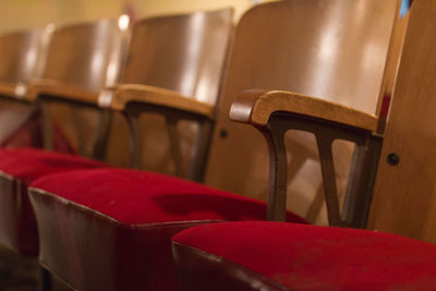 Close-up of wooden chairs at auditorium