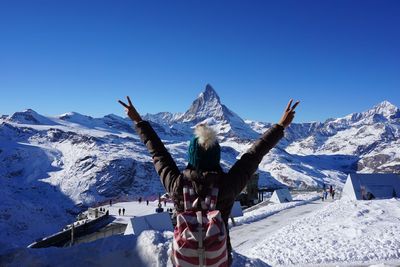 Woman in snow covered mountain against clear blue sky