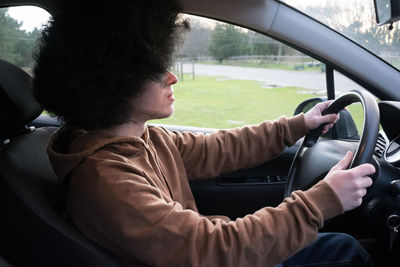 Side view of man sitting in car