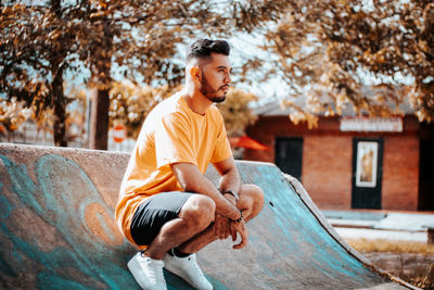 Side view of young man sitting on chair