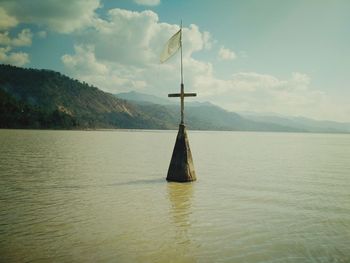 Sailboat in lake against sky