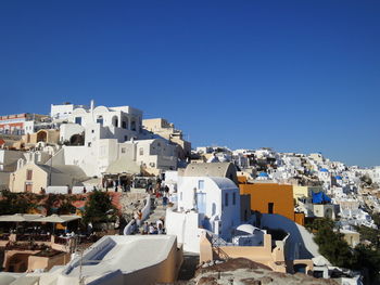 Buildings in town against clear blue sky