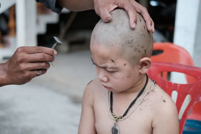 Cropped image of boy having haircut