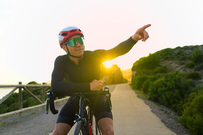 Cyclist spotting a place while resting on the road