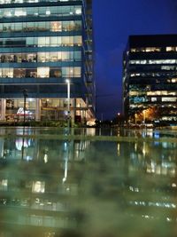 Reflection of illuminated buildings in city at night