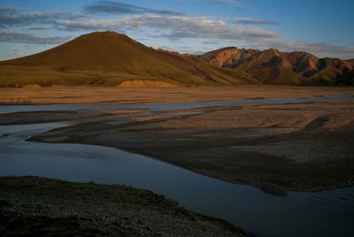 Scenic view of desert against cloudy sky