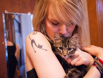 Close-up of cat with hand