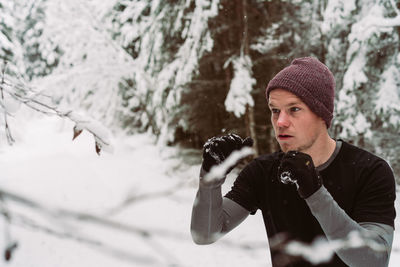 Man jumping by snowy tree