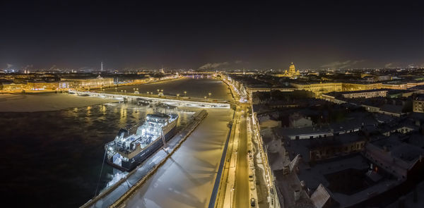 High angle view of illuminated city against sky at night