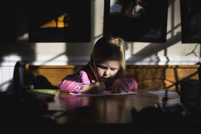 Portrait of girl looking at table at home