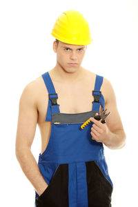 Portrait of young man standing against white background