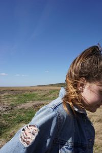 Woman on field against clear blue sky