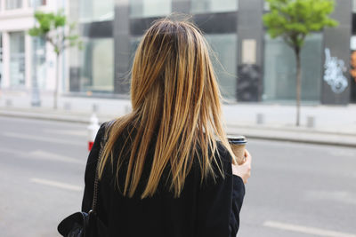 Rear view of woman walking on street in city