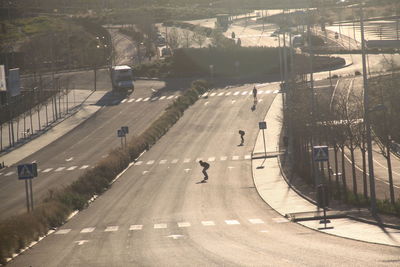 Silhouette of people skateboarding on road