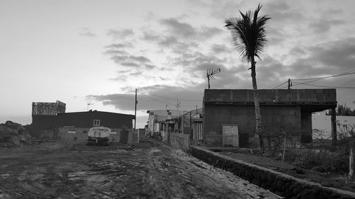 Houses on field by buildings against sky