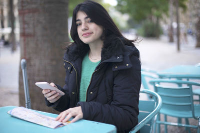 Young woman using mobile phone in city