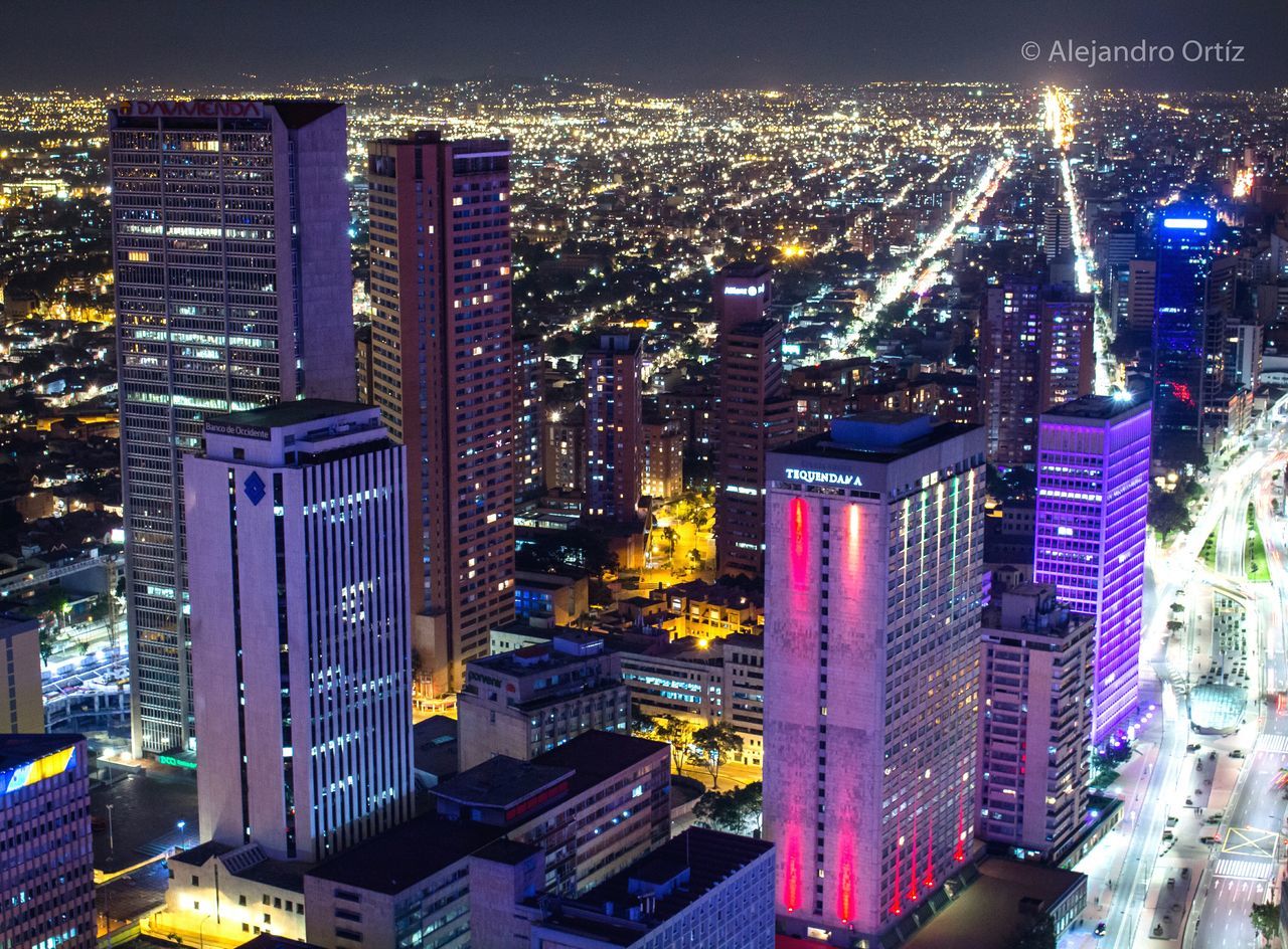 AERIAL VIEW OF ILLUMINATED CITY AGAINST SKY AT NIGHT