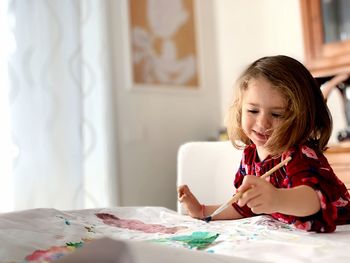 Portrait of a smiling girl sitting on table